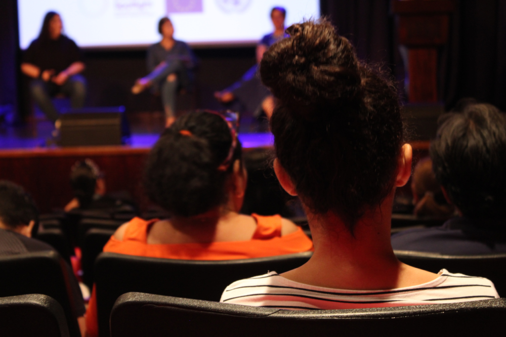 Mujer de espalda en un foro organizado por la colectiva